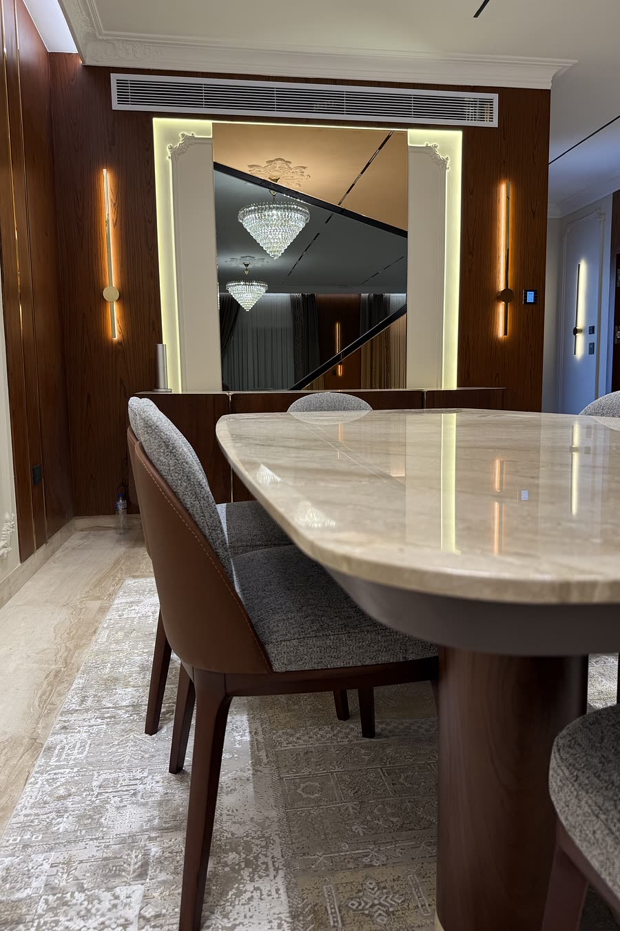Hyde Park dining table in marble under a crystal chandelier
